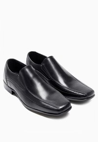 Czarne skórzane buty wsuwane o eleganckim designie, w kształcie spiczastego nosa i subtelnych detalach szycia. Gładka faktura z niskim obcasem.