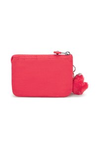 Pochette en tissu rose avec fermeture éclair, ornée d'un charm en forme de cœur fluffy attaché à la zip pour un détail supplémentaire.