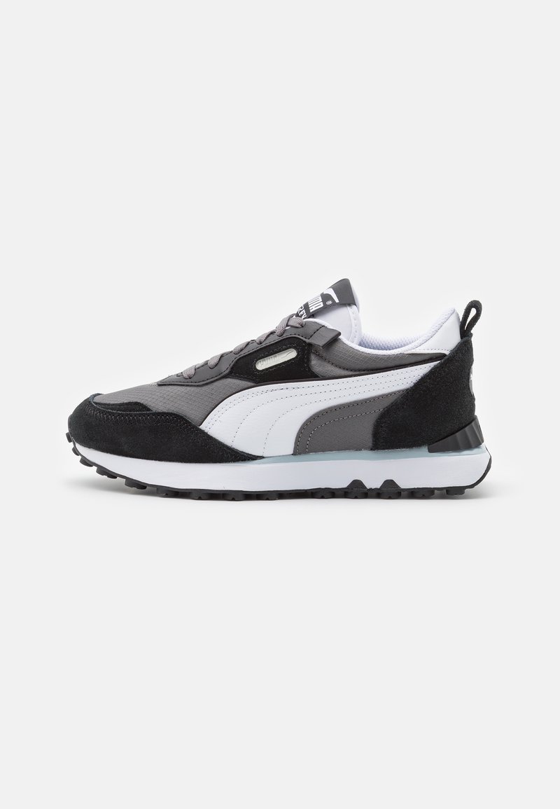 Chaussure de sport basse grise, noire et blanche avec logo Puma blanc, détails en daim noir, fermeture à lacets et semelle en caoutchouc texturée.