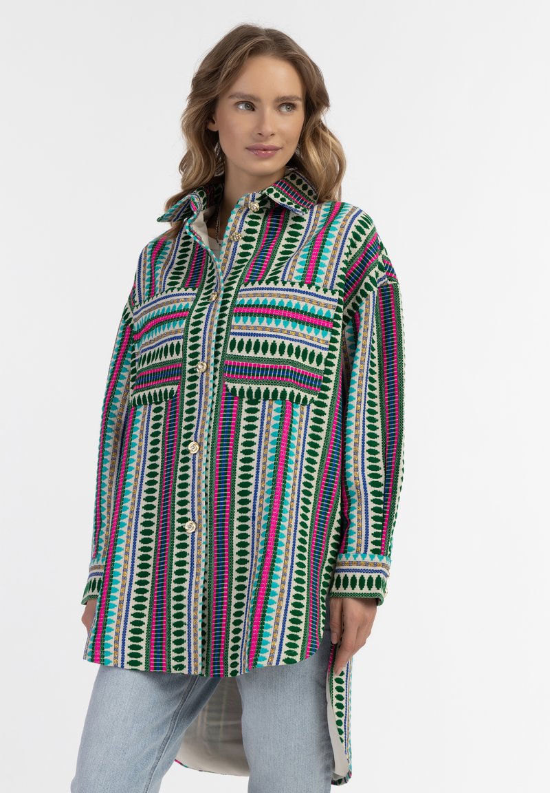 Marškiniai su daugiaspalviu raštu, kuriame yra žali, rožiniai ir mėlyni dryžiai, du priekiniai kišeniai ir ilgesnis nugaros krašto dizainas.