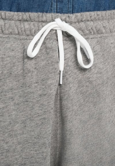 Sivé bavlnené tepláky s elastickým pásom a bielym šnúrkou. Tkanina má jemný, textúrovaný vzhľad s jemným melírovaným vzorom.