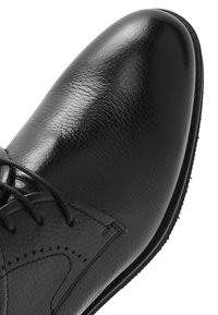 Czarny skórzany but wizytowy z zapięciem na sznurowadła, szczegółowym przeszyciem i gładkim, zaokrąglonym noskiem.