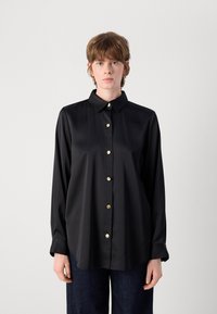 Camisa de cetim preta com colarinho, mangas longas e botões dourados na frente. Textura suave; ajuste ligeiramente oversized.
