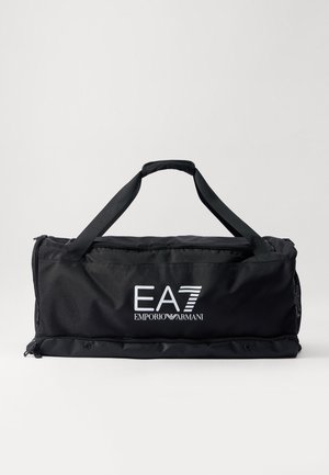Sac de sport noir en tissu durable, doté de deux poignées solides, d'une fermeture éclair, et de logos blancs sur le devant pour le branding.
