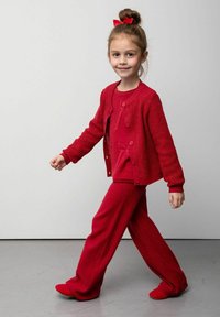 Czerwony dziergany kardigan z dopasowanymi długimi spodniami i butami wsuwanymi. Wykonany z teksturowanej tkaniny, z okrągłym dekoltem. Uzupełniony czerwonym kokardą we włosach.