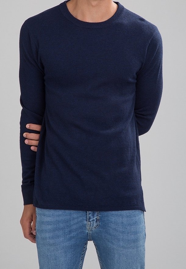 Granatowy sweter dziany z okrągłym dekoltem, długimi rękawami i ściągaczem na dole. Połączony z jasnoniebieskimi dżinsami. Gładka faktura, klasyczny fason.