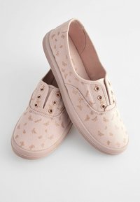 Scarpe slip-on in tela di un morbido rosa con una delicata stampa dorata di farfalle, dotate di occhielli in metallo e una suola in gomma testurizzata.