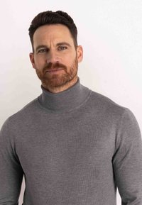 Grauer Rollkragenpullover mit figurempfindlichem Design, geripptem Kragen und glatter Textur. Unverziert, ohne Muster oder sichtbare Beschläge.