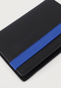 Μαύρο δερμάτινο πορτοφόλι με μπλε ελαστική λωρίδα κλεισίματος, ανάγλυφο λογότυπο μπροστά και λεία, ματ υφή.