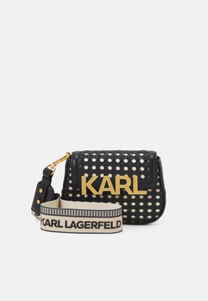 Czarna pleciona torebka na ramię z dużym złotym napisem "KARL" na klapie i beżowym, regulowanym paskiem z brandingiem "KARL LAGERFELD" w czarnym tekście.