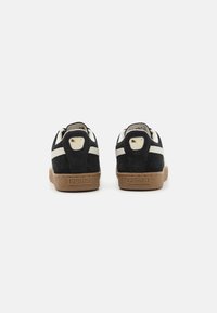 Mustad nahast tennisekad beige aktsentidega, ümmargune kuju, valged triibud külgedel ja pruun tekstuuriga kummine välistald. Puma logo kandadel.