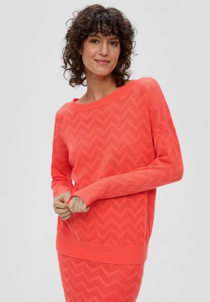 Pull en maille corail avec un motif en chevrons, encolure bateau large, manches longues et poignets côtelés. Léger et texturé avec un design respirant.