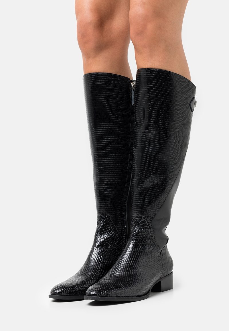 Schwarze kniehohe Stiefel aus strukturiertem Kunstleder. Mit spitzer Zehenform und einem seitlichen Reißverschluss. Glatte Oberfläche mit schuppenartigen Details.