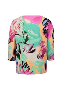 Loose-fitting, three-quarter sleeve top featuring a vibrant abstract pattern in pink, green, and black against a beige background. Soft fabric texture.
