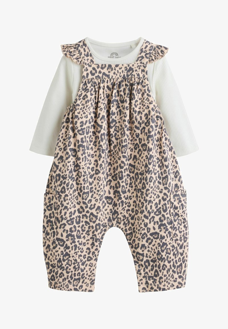Peto de bebé con estampado de leopardo beige y negro y camiseta blanca de manga larga acanalada debajo, con tirantes fruncidos y bolsillos a los lados.