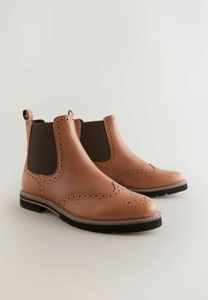 Leder-Chelsea-Boots in Hellbraun mit dunkelbraunen elastischen Seitenpartien, Brogue-Details an der Spitze und einer Gummisohle für besseren Halt.