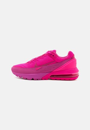 Felroze sportschoen met mesh bovenwerk, gewatteerde middenzool, zichtbare luchtunit in de hiel en Swoosh-logo aan de zijkant, zijaanzicht.