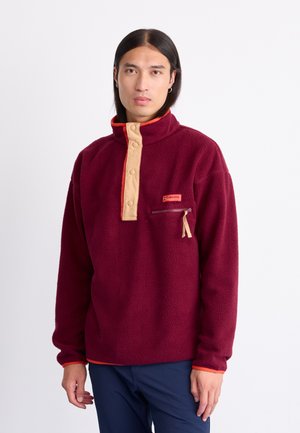 Burgunderfarbener Fleece-Pullover mit beigem Knopfleisten und Brusttasche, orangefarbene Akzente am Kragen und an den Bündchen, weicher Stoff.