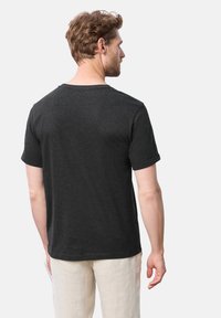 Mörkgrå t-shirt med korta ärmar i mjukt bomullstyg, med rund halsringning och avslappnad passform, sedd bakifrån.