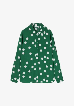 Chemise longue à manches vertes avec col boutonné, ornée de grands pois blancs et de boutons verts assortis sur le devant.