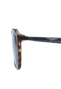Occhiali da sole tartarugati con lenti scure, dotati di un'asta nera lucida e un accento in metallo argentato con il logo 'POLICE'.