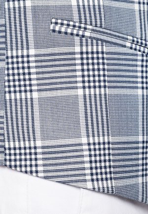 Granatowo-biała tkanina w kratę, z różnymi wzorami w kratkę, o kontrastujących fakturach i gładkiej powierzchni. Zawiera detal w postaci kieszeni.