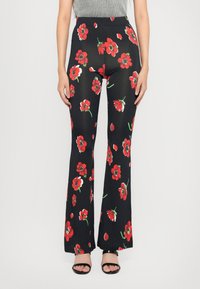 Bredde bukser i svart stoff med et levende blomstermønster med røde blomster og grønne stilker. Elastisk linning for komfort.