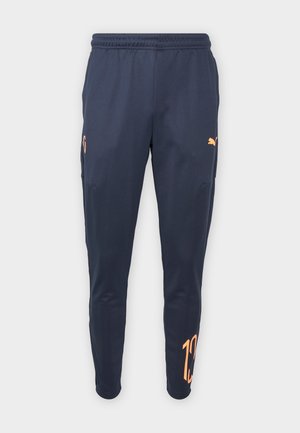 Marineblaue Sporthose mit elastischem Bund, orangefarbenem Puma-Logo am Oberschenkel und großer orangener Zahl "10" nahe dem rechten Knöchel.