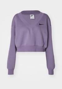 Lavendel beskuren Nike sweatshirt med långa ärmar, V-hals, ribbade muddar och nederkant, samt svart Nike swoosh-logotyp på vänster bröst.