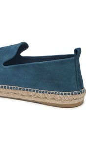 Blauer Wildlederschuh mit strukturierter Oberfläche, geschlossenem Absatz und elastischem Einstieg. Verfügt über eine natürliche Schnursohle und eine Markenkennzeichnung an der Seite.