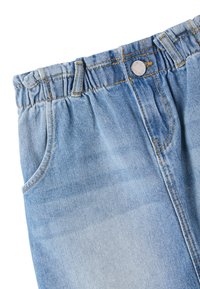 Jeans in denim azzurro chiaro con vita elastica arricciata, bottone metallico e design a cinque tasche. Texture sbiadita nella zona della coscia.