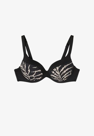 Mustikas prantsus, millel on polsterdatud tassid ja reguleeritavad rihmad. Tassidel on kreemikas ringikujuline muster ja sile kangast tekstuur.