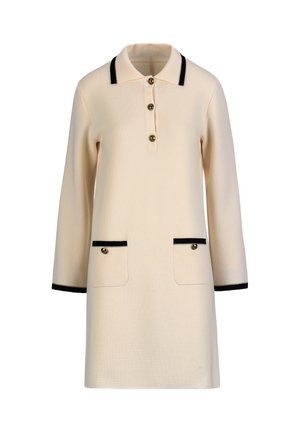 Kremna polo obleka z dolgimi rokavi s črnim trakom na ovratniku, manšetah, dveh sprednjih žepih in tremi gumbi na sprednji odprtini.