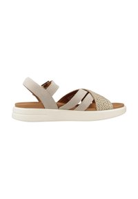 Beige mockaskinnsandaler med vävda detaljer, som har en platt vit sula, justerbart vristband och korsad remdesign.
