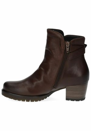 Bottine en cuir marron avec une fermeture éclair sur le côté, bout rond, talon texturé et semelle en caoutchouc. Présente un léger brillant et des accents cousus.