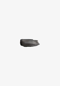 Black mascara brush stroke showing textured lines against a plain white background.