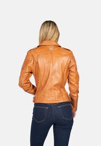 Giacca da moto in pelle marrone con un design aderente, accenti rigati sulle spalle, cintura in vita e dettagli in metallo argentato.