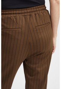 Bruine gestreepte broek met een geplooide tailleband, twee achterzakken en een gladde textielafwerking.