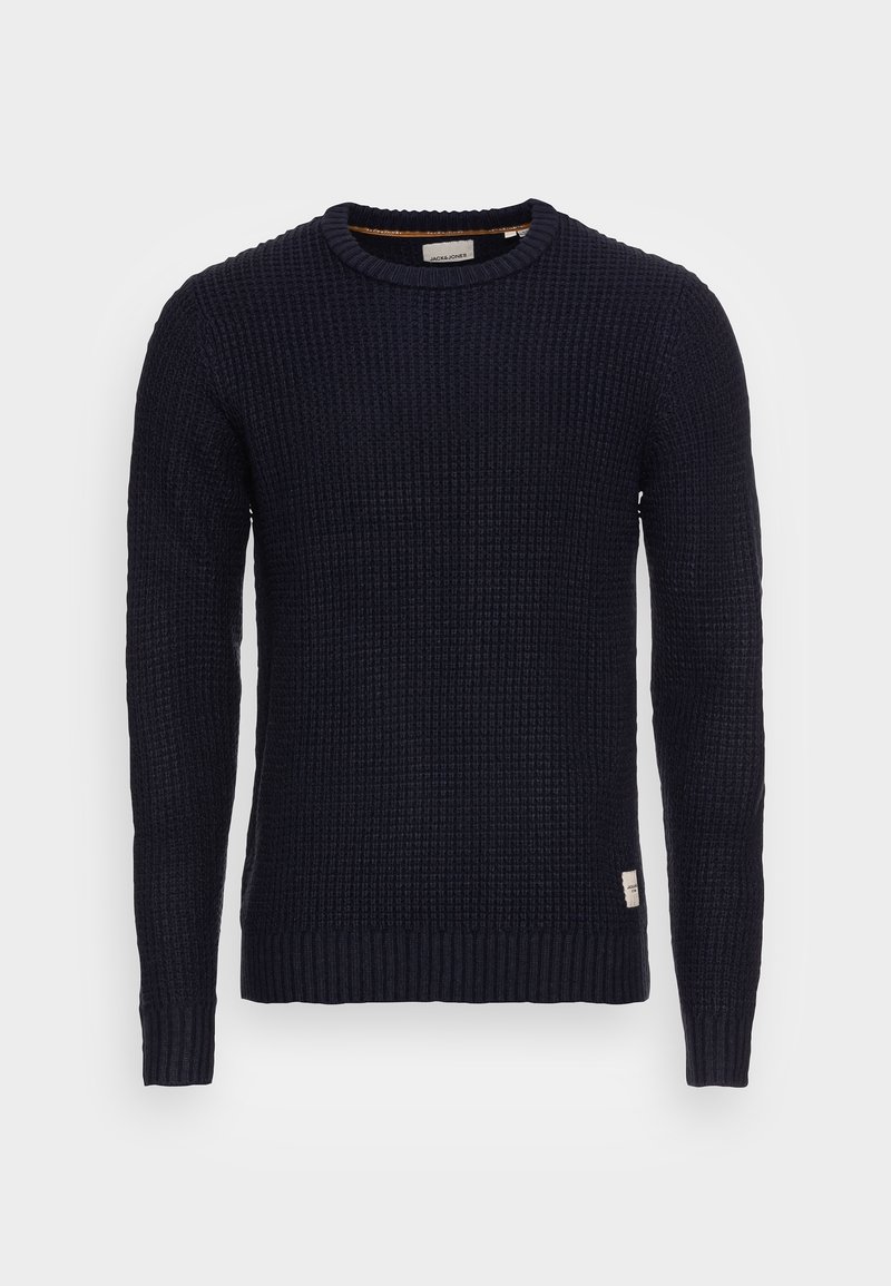 Pull en tricot bleu marine avec un motif texturé, col rond, et poignets et ourlet côtelés. Il est orné d'une petite étiquette en bas à gauche.