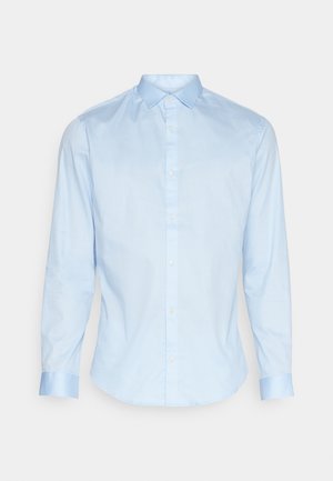 Hele sinine puuvilla pikkade varrukatega särk nuppudega kraega. Omab ümarat hemmi ja kontrastseid mansettide detaile. Sile tekstuur.