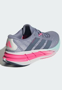Sport shoes with a gray mesh upper, pink accents, and a multi-textured sole featuring a thick pastel heel and stripes for support.