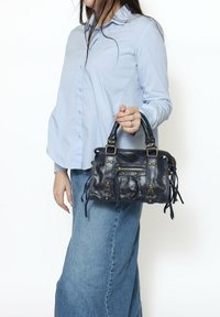 Borsa a tracolla in pelle nera con dettagli in oro, tasca con zip e dettagli con frange. Forma compatta e squadrata con due manici superiori.