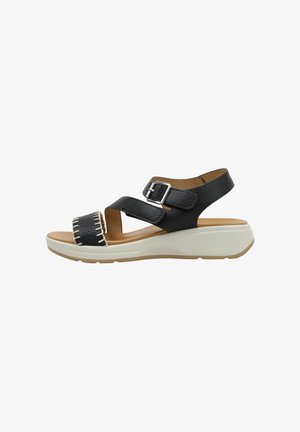Sandale en cuir noir avec bride réglable à boucle, bout ouvert avec coutures blanches, et semelle plateforme blanche rembourrée.
