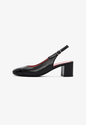 Zapato slingback de cuero negro con tacón ancho y punta redondeada, que presenta una correa con hebilla y forro interior rojo.