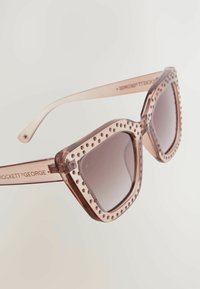 Üks suur roosa prillid läbipaistva raami ja nurgakividest detailidega ääres. Gradient tumedad läätsed, sirged varsid brändingu peal.