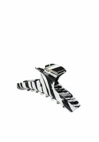 Clips per capelli a strisce bianche e nere, realizzati in plastica lucida, con un design curvo e molteplici denti di presa per una tenuta sicura.
