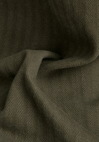 Olivgrön tyg med fiskbensmönster, med en mjuk textur och draperad utseende som framhäver dess vävda struktur.