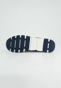 Podeszwa buta w granatowym i białym kolorze, z wzorzystym bieżnikiem dla lepszej przyczepności. Teksturowane materiały z zakrzywionym kształtem palców i solidnym wsparciem pięty.