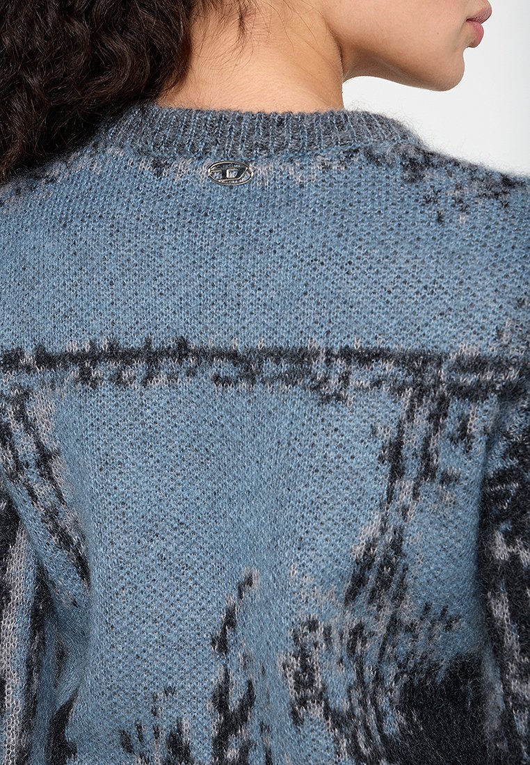 Blauer Strickpullover mit einem strukturierten Muster in Schwarz, einem runden Ausschnitt und einem kleinen metallischen Detail auf der Rückseite.