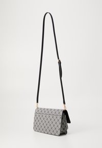 Borsa a spalla rettangolare con motivo ripetuto in bianco e nero, tracolla nera regolabile e accessori in tonalità oro su sfondo semplice.